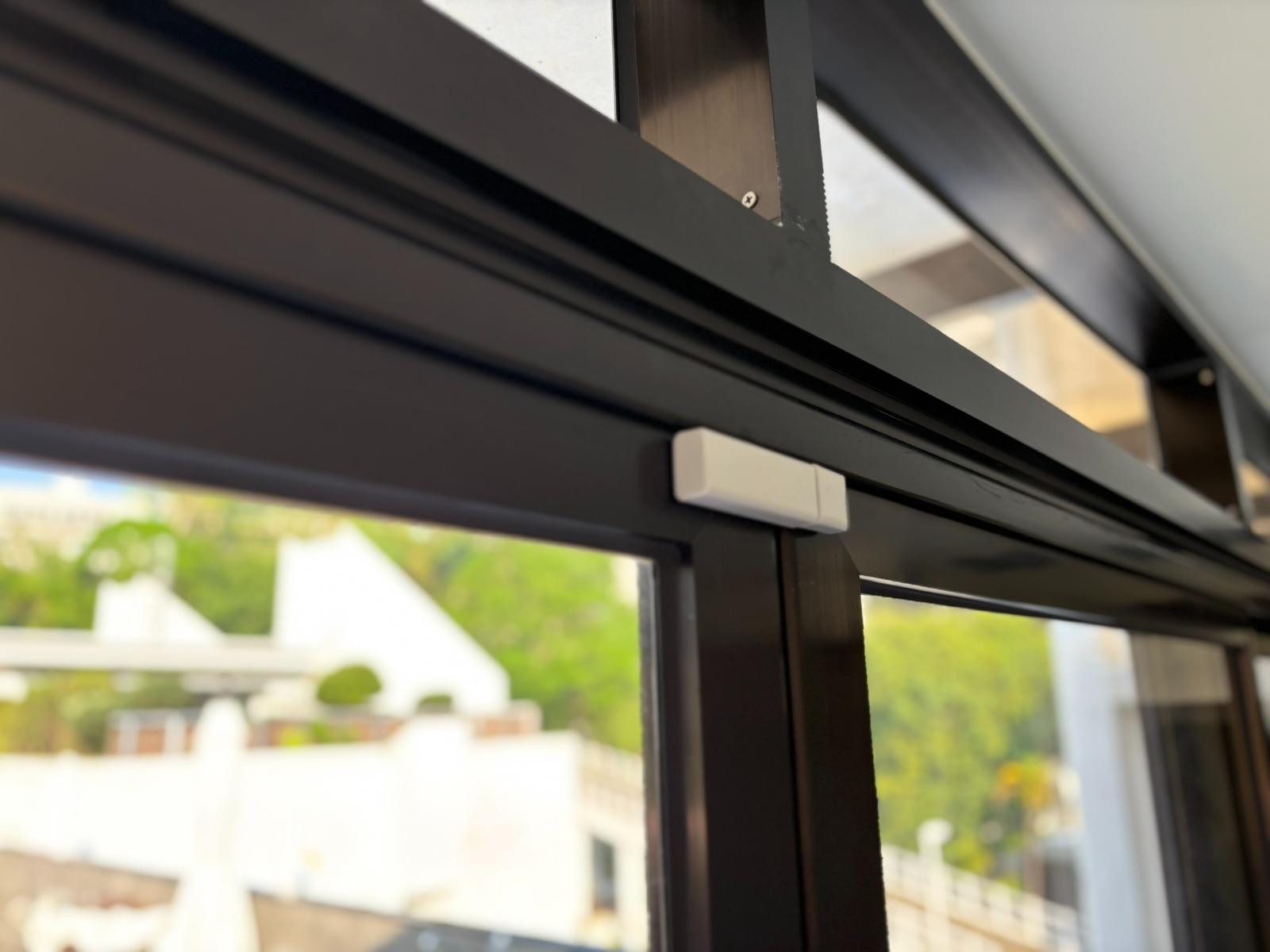Real Apeiron Guard door sensor installed at the top of a finished door frame