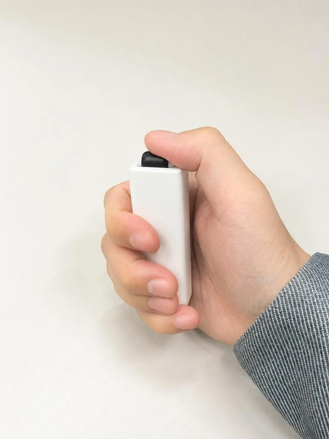 Hand pressing the black roller on an Apeiron Guard Window Sensor